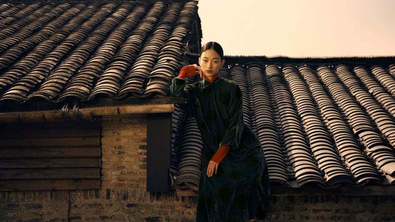 A woman in a traditional Chinese outfit sits on a roof
