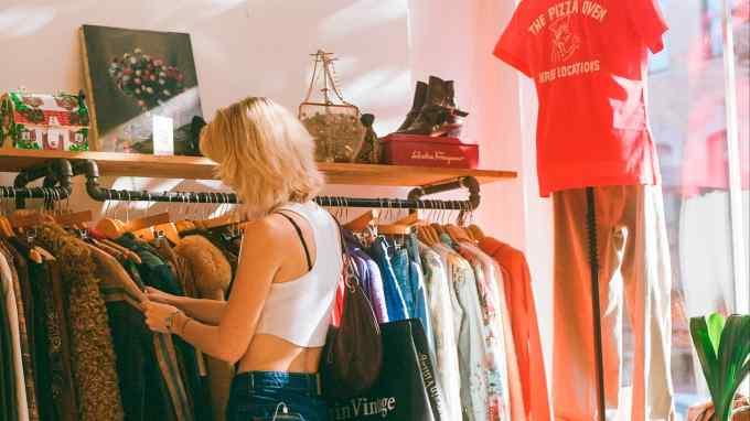 A shopper at Seven Wonders Collective, New York A female shopper browsing a rack of clothes at Seven Wonders Collective, New York
